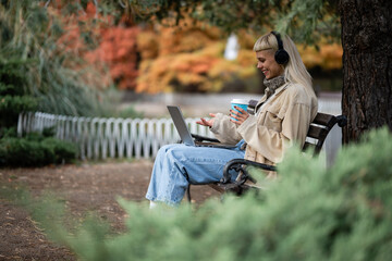 Obraz premium Woman having video call in park with coffee
