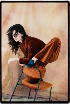 Artistic portrait of woman in velvet suit and chair
