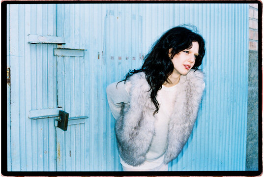 Woman leaning forward in fur vest