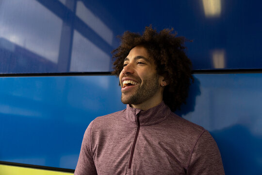 Mixed race man smiling blue background