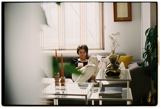 Relaxing in a Cozy Living Room While Using a Mobile Device