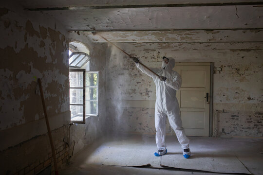Worker Cleans Abandoned Room in Protective Gear