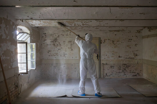 Worker Cleans Old Room With Attention to Safety Measures