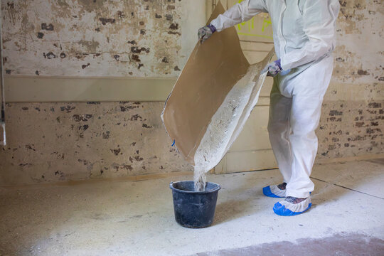Worker Pours Material Into Bucket in Renovation Project