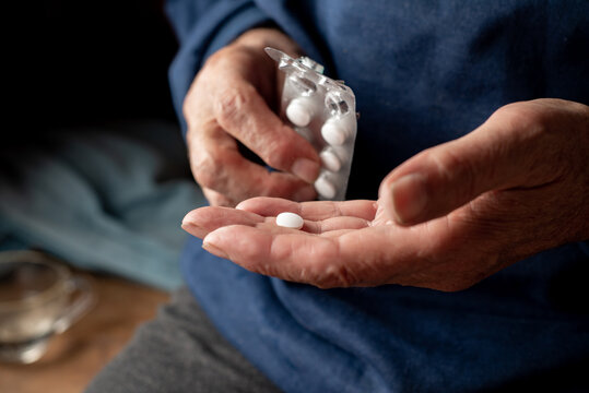 White  Pill and blister in the hands of an elderly man