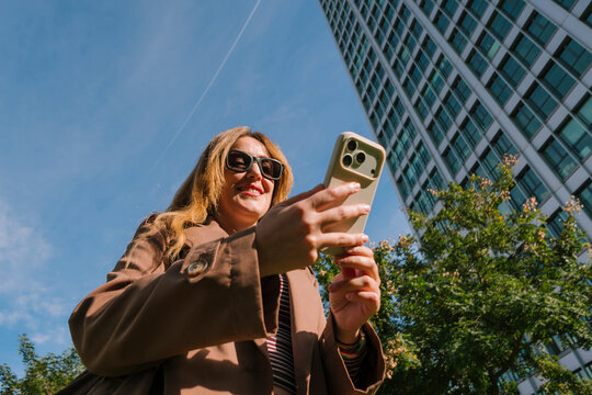Woman scrolling smartphone outdoors