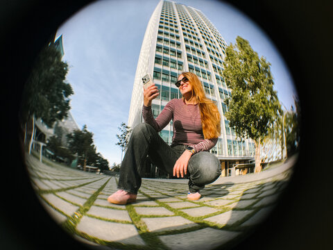 Woman crouching using phone