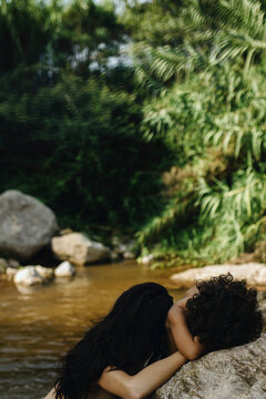 Mother and Child Enjoying Nature by a Tranquil Stream