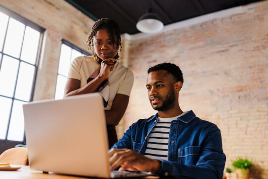 Business people collaborating on laptop in modern office