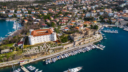 Obraz premium Aerial view of Kraljevica vibrant marina. Historic charm meets Adriatic beauty, with boats dotting the turquoise waters under a clear sky. A perfect Croatian escape.