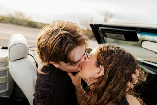 Boyfriend and girlfriend kissing in convertible 