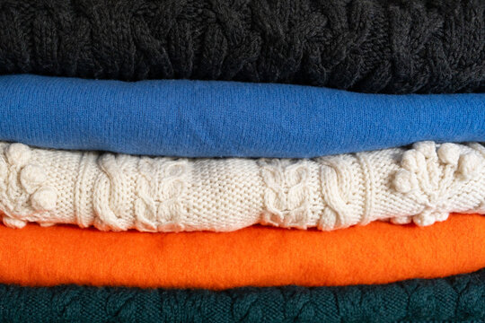 Stack of colorful folded winter sweaters  
