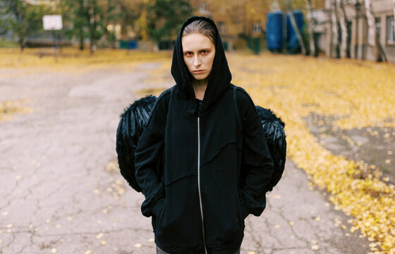 Person With Black Wings Stands in a Park During Autumn
