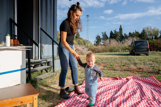 Mother helping infant son learn walking