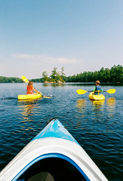 Kids kayaking together on a lake in Maine