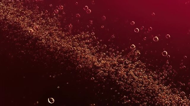 A dark red background shows golden bubbles floating in various sizes, creating dynamic textures