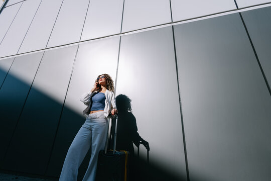 Woman with smartphone and suitcase 