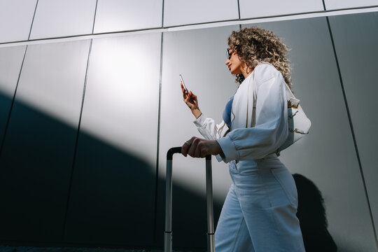 Woman with smartphone and suitcase 