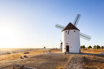 Spanish windmills standing together on hill at sunset