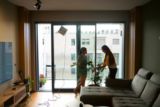 Women setting up plants moving into new apartment