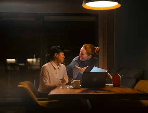 Colleagues collaborating late at night in office