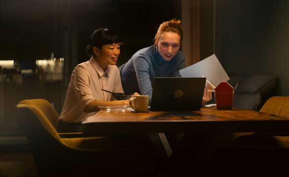 Colleagues collaborating late at night finishing important project