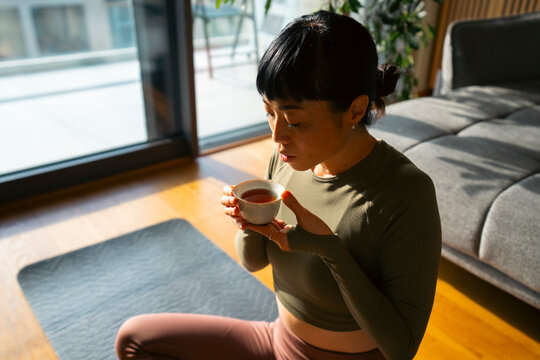 Woman enjoying warm tea after morning yoga session