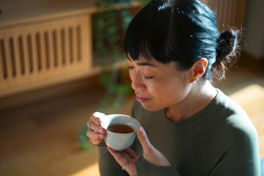 Woman enjoying tea, experiencing calm and mindful relaxation