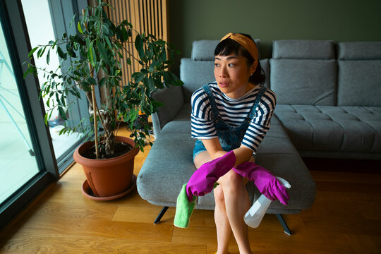 Asian woman taking a break from house cleaning