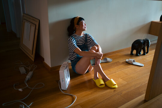 After the day - Woman enjoying sunlight and daydreaming at home
