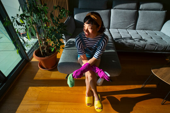 Young woman taking a break from house cleaning