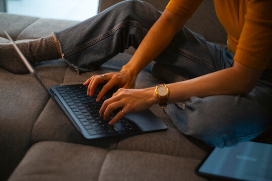 Woman working from home typing on laptop keyboard