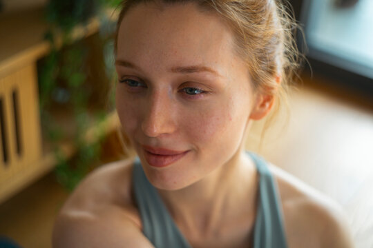 Woman with thoughtful expression practicing yoga indoors