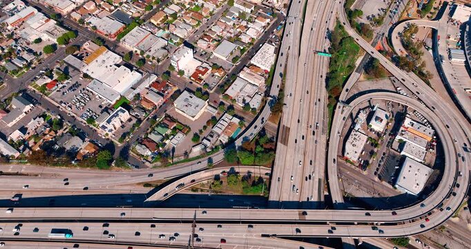 Highways and loops with multiple quickly moving cars. Hectic lifestyle of Los Angeles, California, USA. Top view.