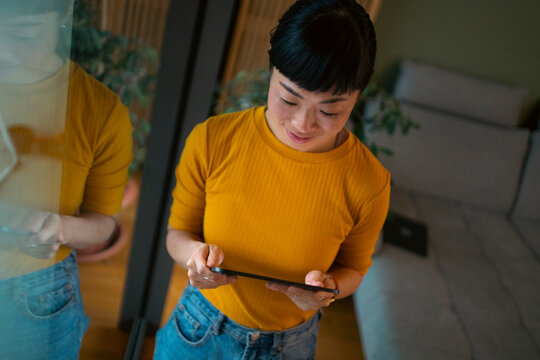 Young asian woman using digital tablet at home
