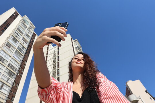 Girl taking a tropical selfie under blue sky