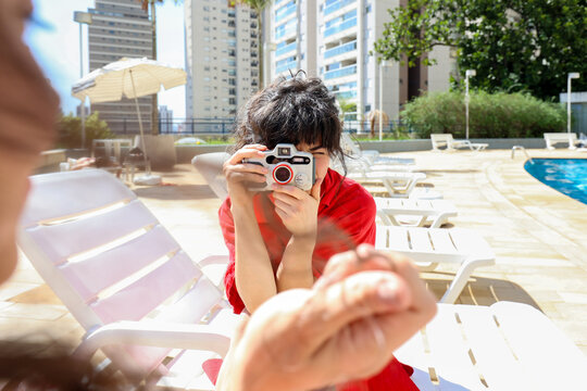 Young Woman photogrpahs by the Pool 