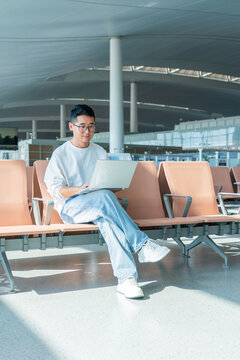 Asian man using laptop at airport