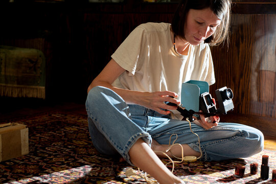 Young woman inserting film to view on a vintage projector