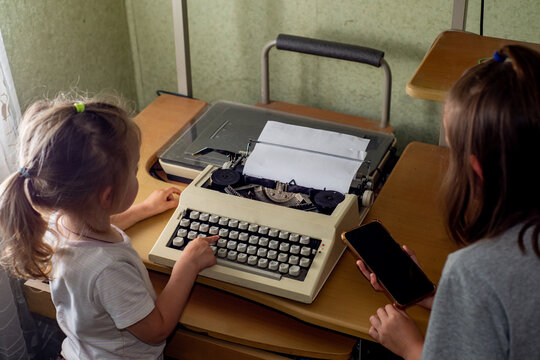 Children looking at an old typewriter