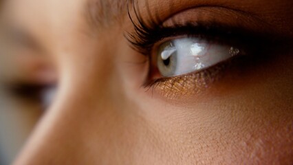 Woman's green eye with long eyelashes looking away