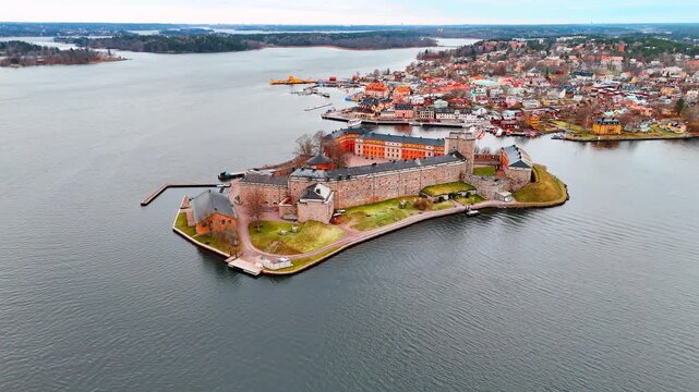Coming closer to the brick walls of Vaxholm Fortress on Vaxholmen islet. View on the scenery of Stockholm archipelago, Sweden on a dull day.