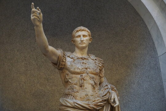 Frontal close up of a marble statue depicting the ancient Roman emperor Augustus giving a salute