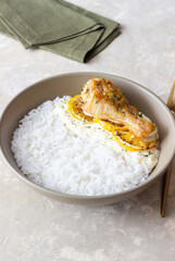 Baked chicken leg with lemon in a creamy sauce and rice. Recipe.