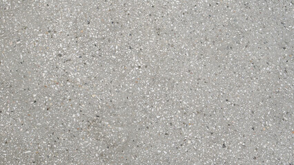 Light gray terrazzo concrete surface with small white and dark stone chips, flat lay texture background. © SIV Stock Studio