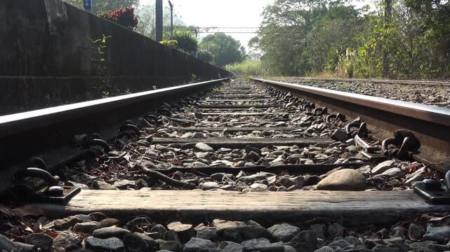 Gleaming rails and wooden sleepers under the sun.