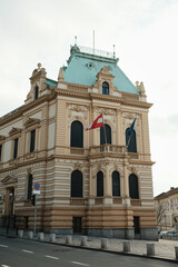Fototapeta premium Austrian Embassy building in Belgrade with ornate historic facade and Austria and European Union flags, symbolizing diplomacy, international relations and official government presence.