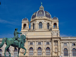 Naklejka premium Natural History Museum Vienna with Flowers - Historic landmark building of the Naturhistorisches Museum on Maria-Theresien-Platz on a vibrant, sunny summer day.