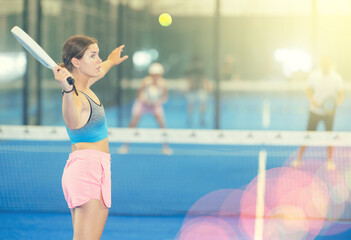 Padel game - girl with partners plays on the tennis court