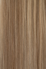 A blonde girl seen from the back with long light brown hair and a trimmed edge